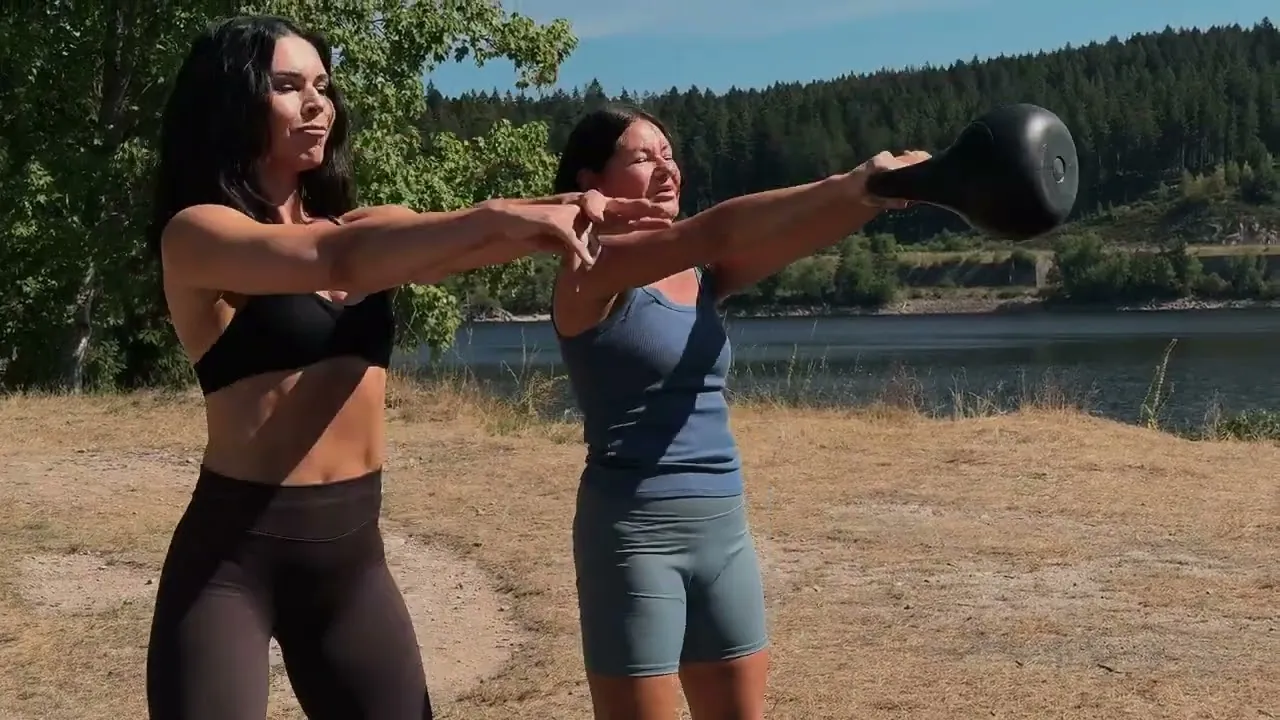 Natalie Siemieinova trainiert eine Kundin mit Kettlebell am See